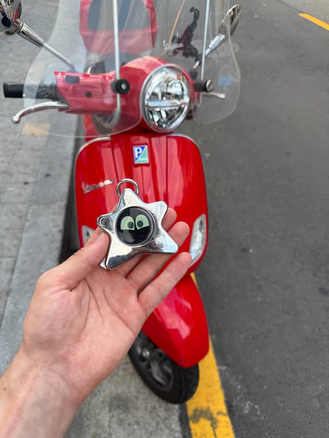 A small expressive camera companion device against a red backdrop